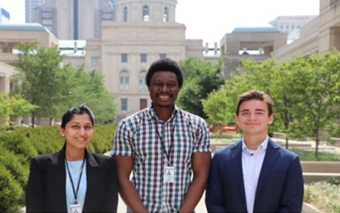 Three students, two male one female, pose in front of the Indiana government building