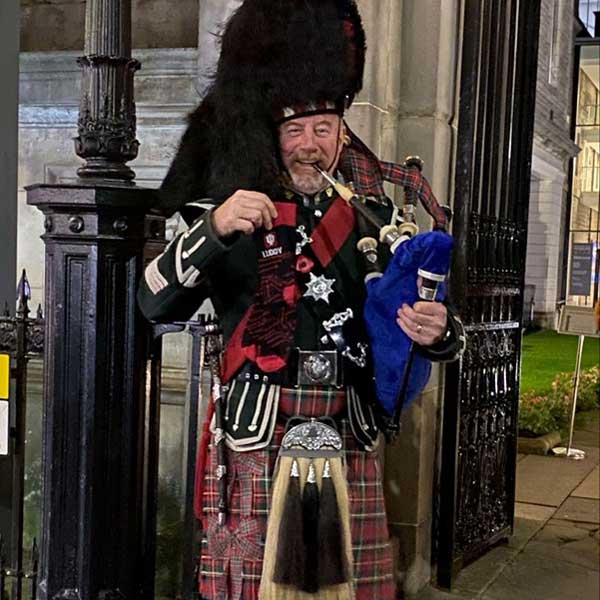 Man with a bagpipe holding Luddy socks