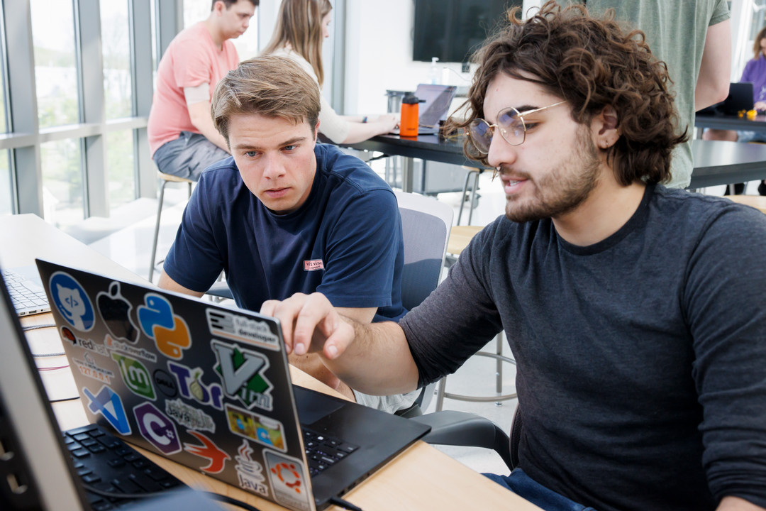 Two students reviewing data together on a laptop